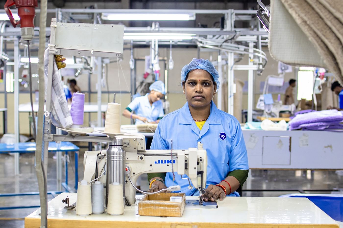 Machinist guiding fabric through an industrial sewing machine